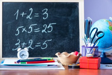 Kahverengi ahşap bir ahşap kırtasiyenin yanındaki okula geri dönük yazılı ahşap levha.