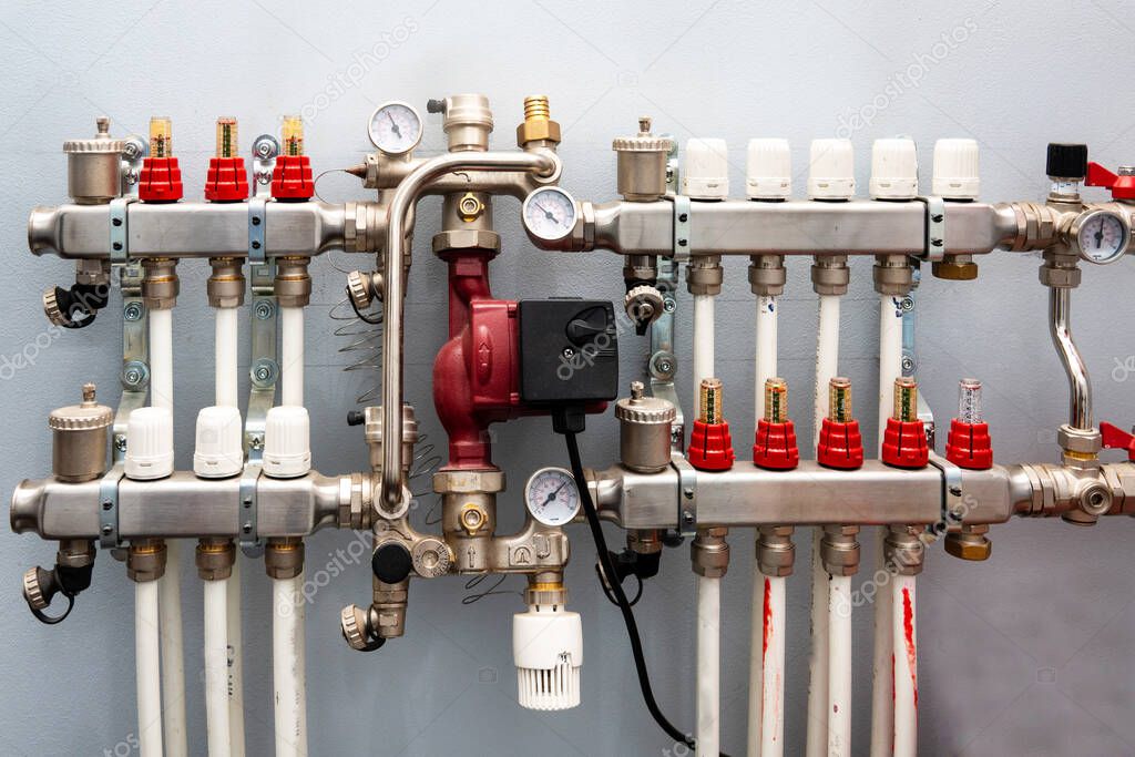 Closeup of manometer, pipes and faucet valves of heating system in a boiler room