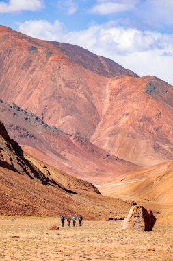 Bir grup turist ve Pamirlerin turuncu dağları.!