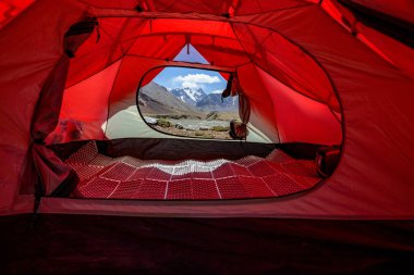 View through the tent to the Muzkolsky mountain range in the Pamirs. clipart