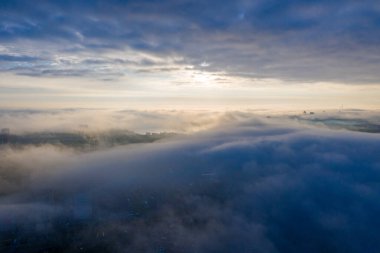 Şehirdeki sislerin arasından güneş doğuyor! Bulutların üstünde ve sisin altında! Bir yerlerde bir nehir!