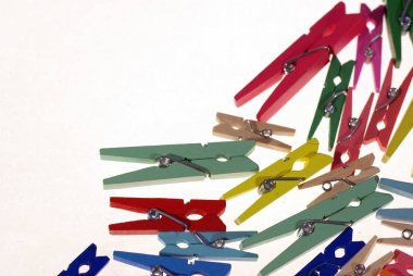 Clothespins. Çok renkli çamaşır iğneleri. Açık bir arka plan üzerinde küçük renkli giysiler mandal
