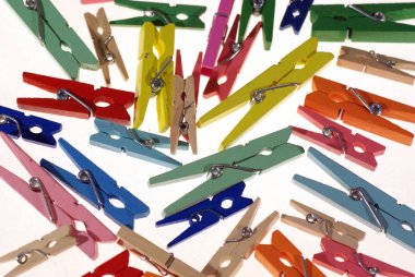 Clothespins. Çok renkli çamaşır iğneleri. Açık bir arka plan üzerinde küçük renkli giysiler mandal
