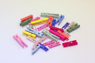 Clothespins. Çok renkli çamaşır iğneleri. Açık bir arka plan üzerinde küçük renkli giysiler mandal