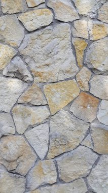 Doğal taş. Duvar doğal kumtaşından yapılmıştır. Taş süsleme