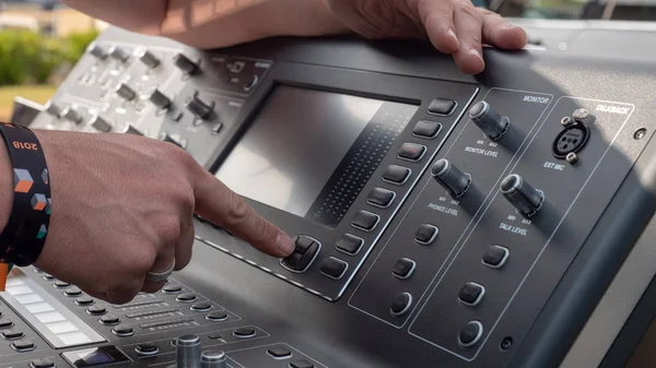 audio engineer prepping his audio mixing console on a television set