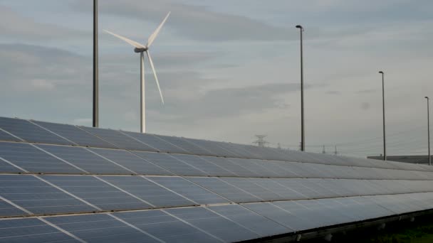 太陽電池パネルの背景に風車と太陽をキャッチ — ストック動画