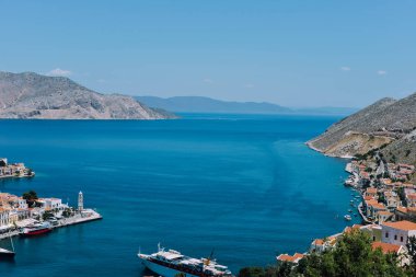 Symi Adası, Yunanistan - Haziran 2018 yaklaşık: hava görünümünü deniz ve liman ve cascade tepe üzerinde parlak binaların güneşli bir Symi Adası Yunanistan.