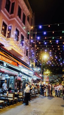İstanbul, Türkiye - Eylül 2019: İstanbul 'un eski tarihi Sultanahmet semtindeki işlek caddelerdeki açık hava restoranında akşam yemeği.
