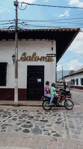 Guaduas Colombia Circa 2020年2月 植民地時代の村の古いスペインの建築と石畳の通りにバイクや自転車の地元の人々曇りの日にGuaduas — ストック写真