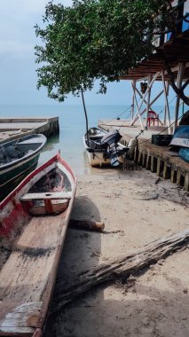 RINCON DEL MAR, COLOMBIA - CIRCA FEBRUARY 2020: Kum ve turkuaz ile sahilde balıkçı teknesi Karayip denizinin küçük balıkçı kasabasında mavi suları.
