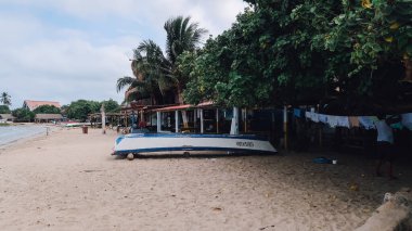 RINCON DEL MAR, COLOMBIA - CIRCA FEBRUARY 2020: Sahilde beyaz kumlu balıkçı tekneleri ve kıyıdaki küçük bir köyde Karayip denizinin mavi suları.