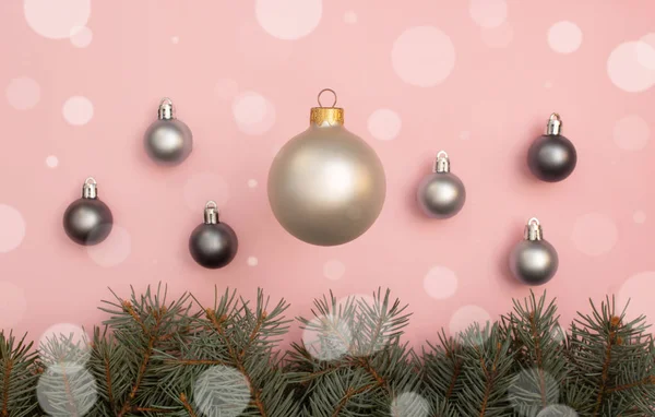 Pearl kerstballen op de roze achtergrond met boom pijnboomtakken — Stockfoto