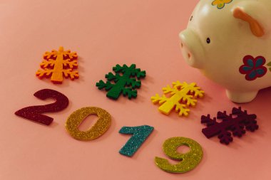 Mutlu yeni yıl 2019 bir kumbara pembe bir zemin üzerine