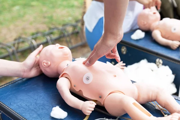 Infant chest compressions practice on a CPR dummy