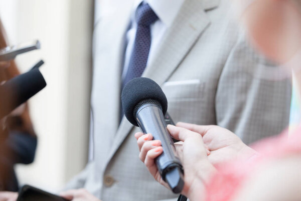 Journalist making media interview with unrecognizable business person or politician