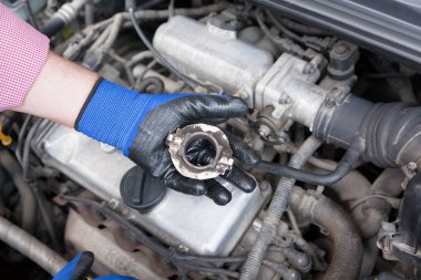 Eski holding otomatik mekanik giyiyor koruyucu iş eldivenleri yayın taşıyan bir araba motoru üzerinde Debriyaj.