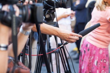 Basın toplantısında mikrofon tutan Tv gazeteci