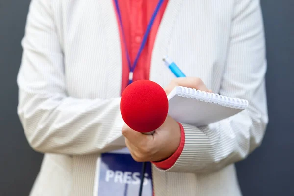 Vrouwelijke Verslaggever Bij Nieuwsconferentie Notities Schrijven Microfoon Vasthouden — Stockfoto