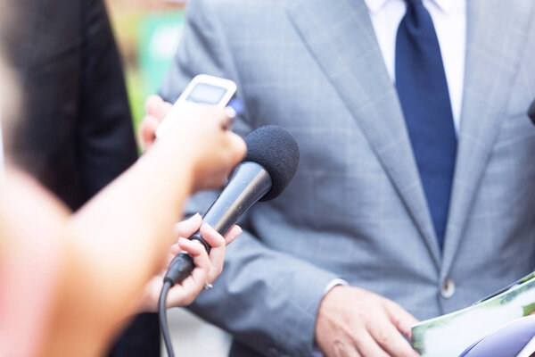 Reporters making media interview with unrecognizable businessman or politician