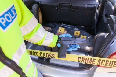 Polis memuru elinde silah yapılan kazılarda bir arabanın, uyuşturucu paketleri içinde belgili tanımlık geçmiş
