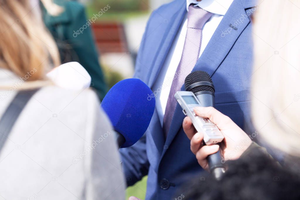 Reporters making media interview with unrecognizable businessman or politician