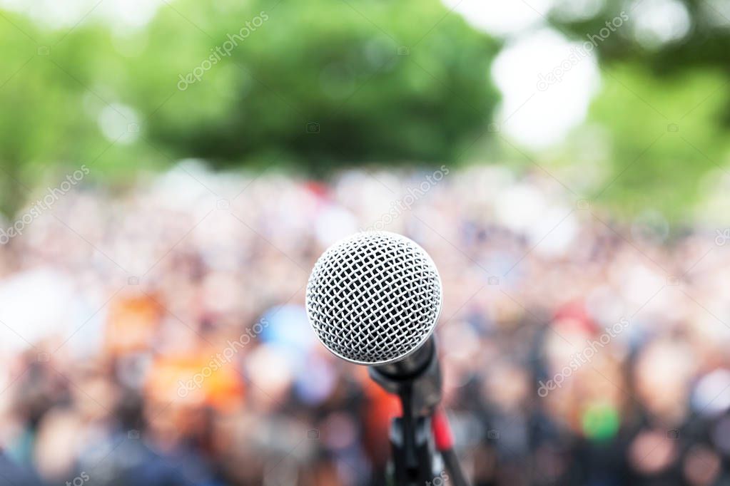 Microphone in focus against blurred protest or public demonstration