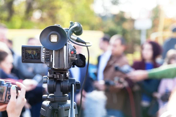 Filming an media event with a video camera. Press conference. Royalty Free Stock Images