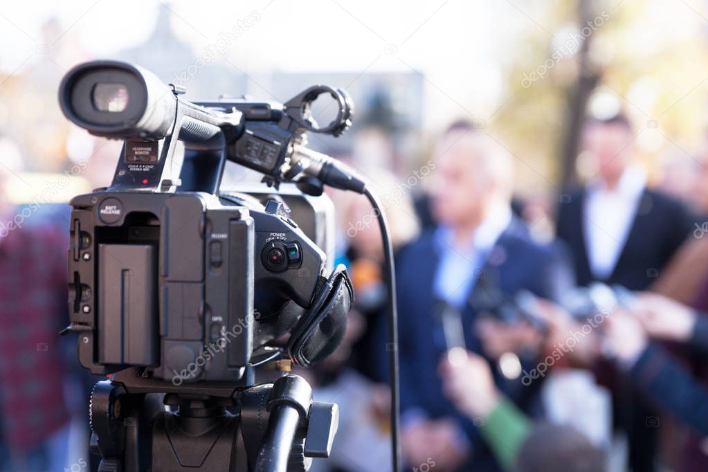 Filming news conference with television camera