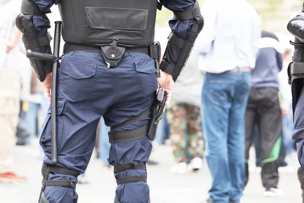 Agente di polizia antisommossa che tiene la mano sulla pistola durante la protesta di strada — Foto Stock