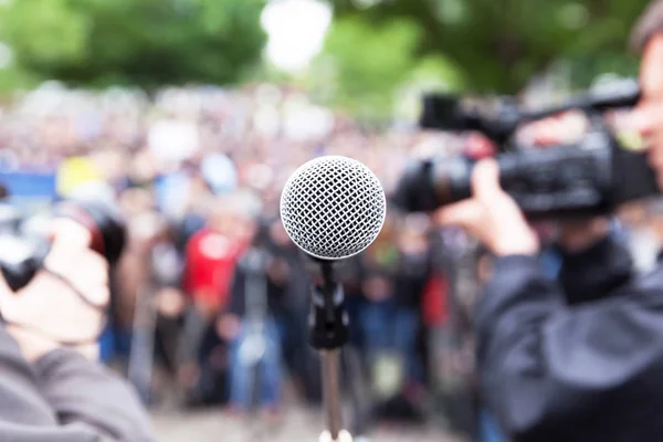 Microfone em foco no protesto de rua, cameraman borrado e fotógrafo em segundo plano — Fotografia de Stock