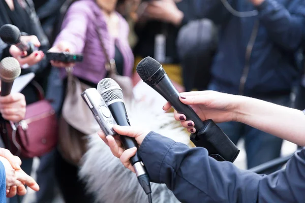 Journalisten die microfoons houden op de persconferentie — Stockfoto