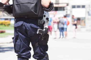Polis memuru görevbaşında, arka planda bulanık insanlar