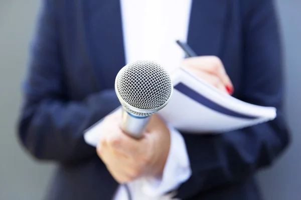 Kvinnlig journalist vid presskonferens eller medieevenemang, anteckningar, mikrofon — Stockfoto