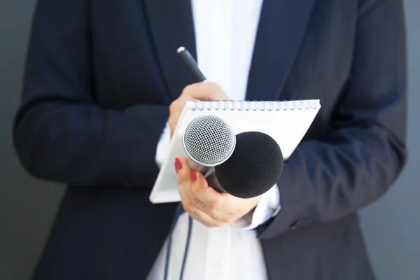 Basın konferansında ya da medya etkinliğinde kadın gazeteci, notlar yazma, mikrofon tutma — Stok fotoğraf