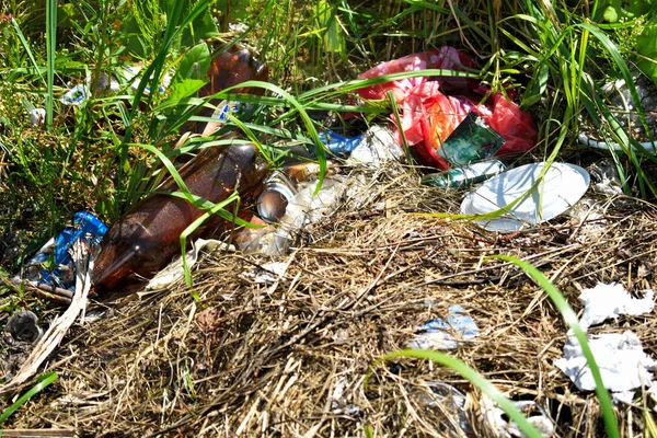 Problema da poluição ambiental. Um monte de lixo em uma grama — Fotografia de Stock
