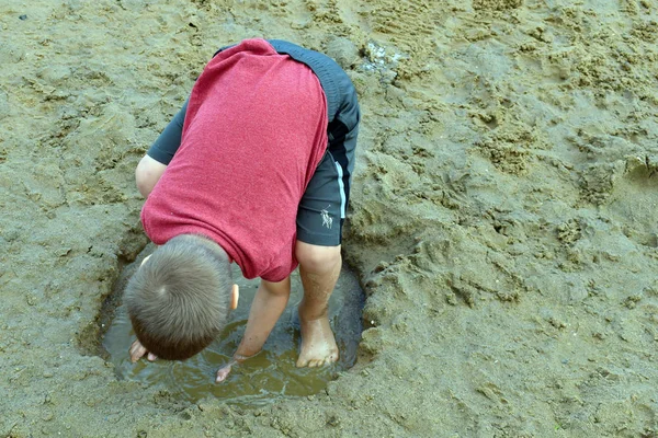 Anak itu bermain kotor di tepi sungai di musim panas. Pelacur anak-anak aktif — Stok Foto