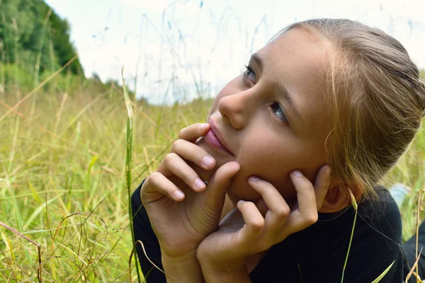 Gadis kecil yang cantik di rumput hijau di musim panas . — Stok Foto