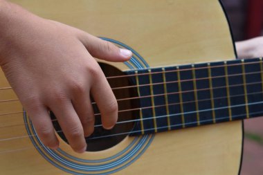 Çocuk yakın gitar çalar. 