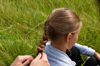 Anne yaz aylarında saç üzerinde kız örgüler.