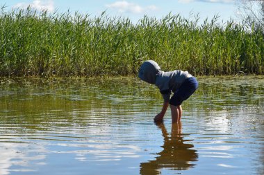 Çocuk balıkları elleriyle yakalar. Neşeli çocukluk.