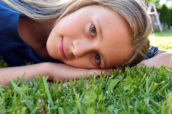 Gadis muda cantik menutup di rumput hijau di musim panas . — Stok Foto