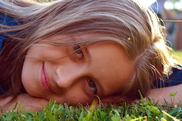 Belle jeune fille gros plan sur l'herbe verte en été . — Photo