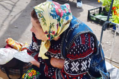 Büyükanne stooped sahip oturur ve alıcı bekliyor.