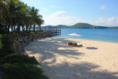 Güzel sahil. Deniz kenarındaki kumlu sahilde sandalyeler. Yaz tatili ve turizm için tatil konsepti. İlham verici tropikal manzara.