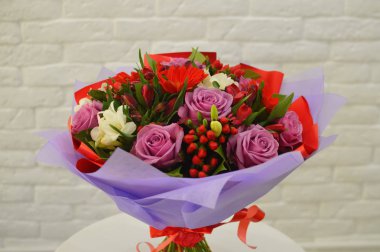 Beyaz bir masa üzerinde şık modern ambalaj pembe güller ile güzel buket. Çiçekçi dükkanı kavramı. Bir tatil için bir kartpostal için romantik buket bir Anneler Günü, Sevgililer Günü. Yakın çekim