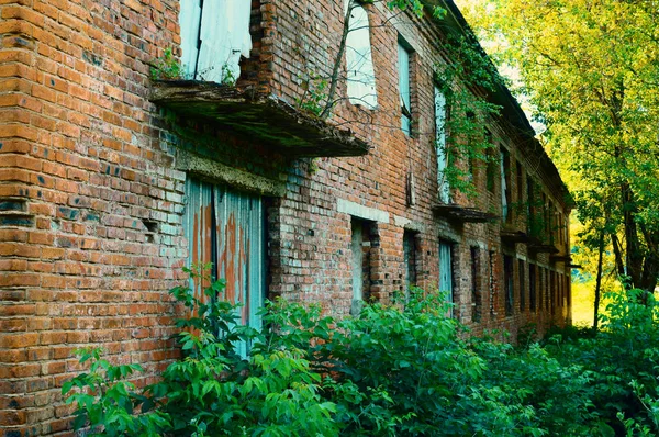 old brick two-storeyed abandoned building. The collapsed barrack from a red brick of last century. Danger of a building collapse.