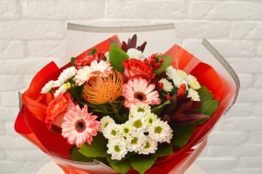 Beyaz masada karışık çiçek yakın çekim güzel güzel buket. Gri arka planda renkli çiçekler yakın çekim güzel buket. Çiçekçi konsepti. Site veya katalog için fotoğraf. Bahar çiçek açan çiçek çeşitleri.