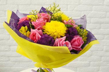 Düğün için yaz çiçek buketkarışımı. Tuğla beyaz duvar arka plan karşı beyaz masada ambalaj renkli çiçekler güzel buket. Kimse yok. Close. Çiçekçi dükkanı kavramı. Katalog için buket.