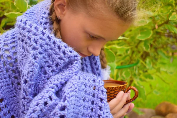 ニット毛布の美しい小さな女の子は熱いお茶を飲みます. — ストック写真